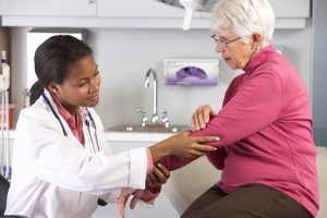 Female Doctor Examining Female Patient With Elbow Pain