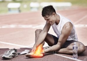 young athlete holding his leg in pain