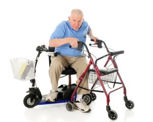 A senior man transferring from his electric scooter to his wheeling walker
